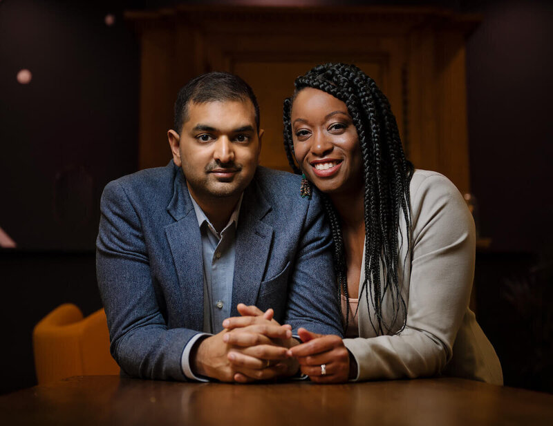 Ajay and LaToya sitting at a table facing the camera