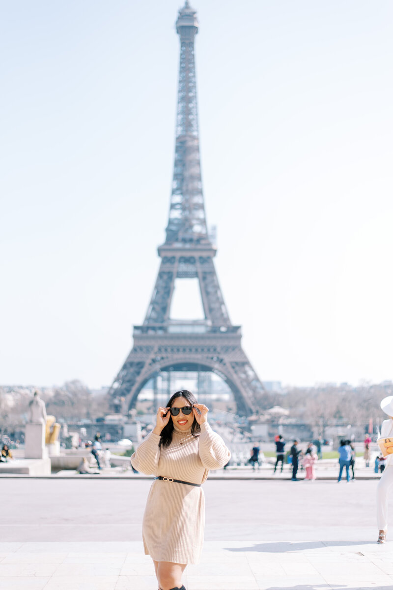 woman standing in front of the eiffel tower in paris wedding photograper