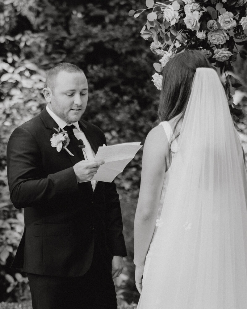 a groom reading his vows to his bride