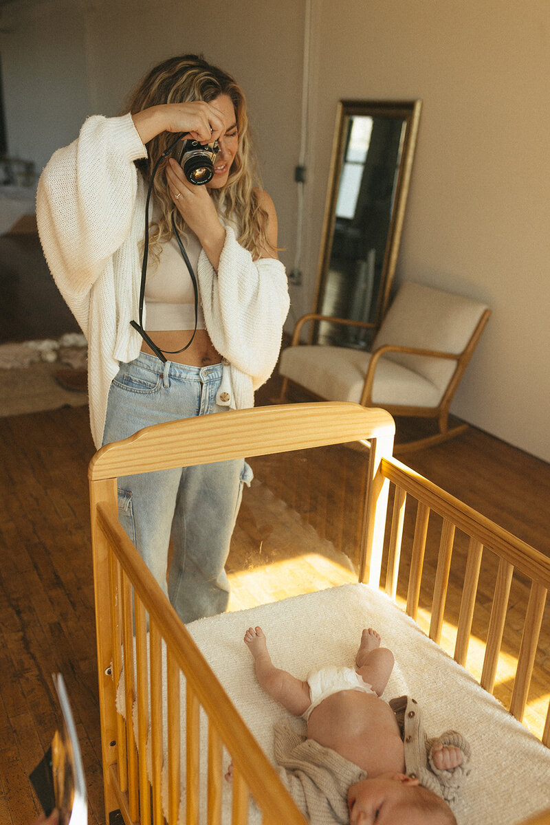 Minnesota photographer smiles into the distance while holding her baby