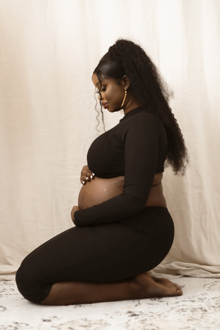 studio maternity session with beautiful pregnant mama kneeling to the ground in my Brookwater Studio Space