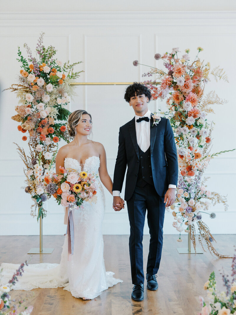 Couple walking from lush and colorful floral alter at a wedding in Portland, Oregon