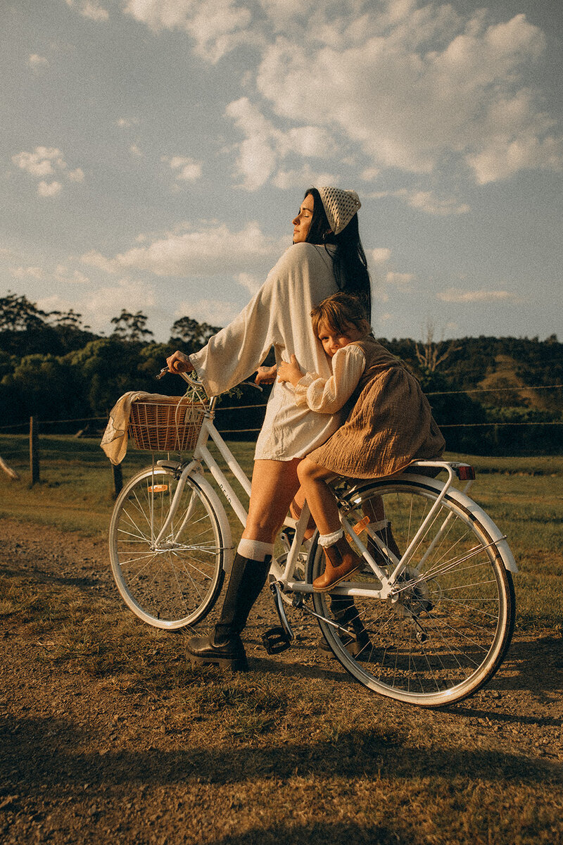 A child cuddling up his mother on a bike a Sunshine Coast family photoshoot