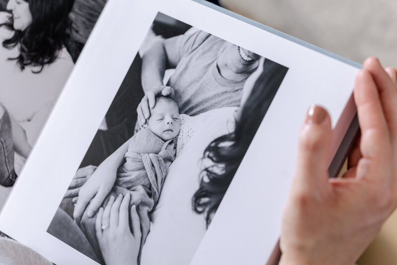 hand holds luxury album of newborn photography