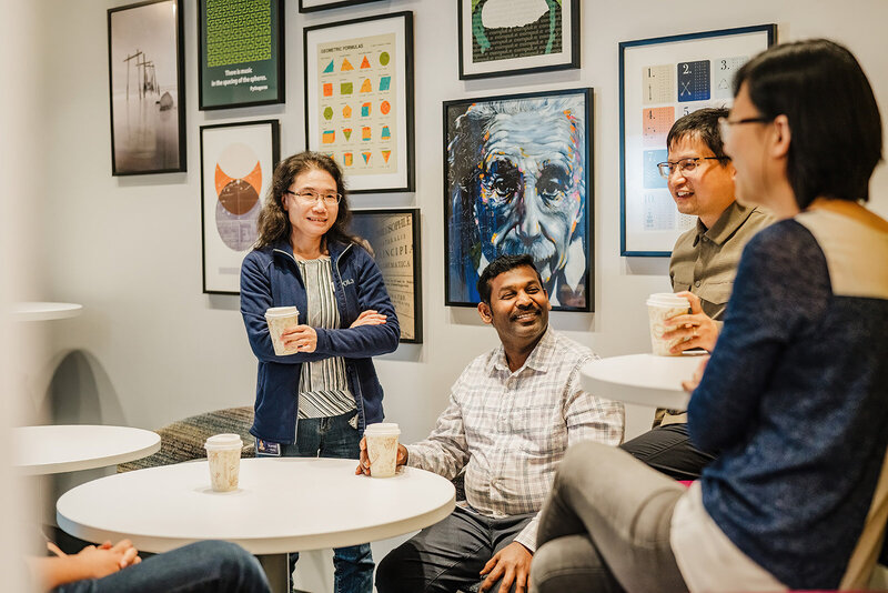 corporate team laughs in breakroom during HR photoshoot in boston