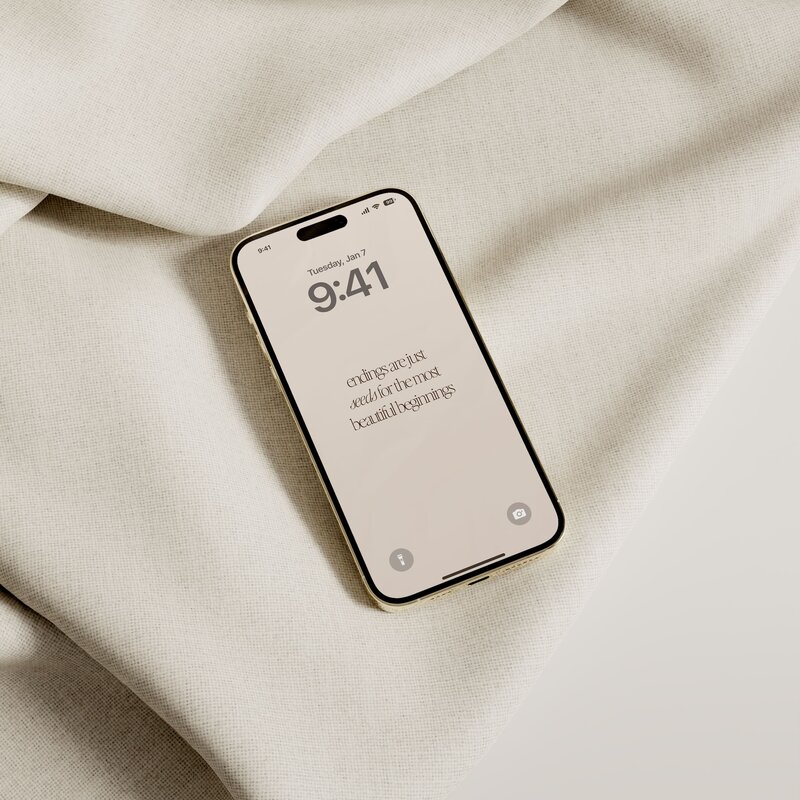iPhone on a soft neutral fabric, featuring an inspirational lock screen wallpaper that reads, ‘Endings are just seeds for the most beautiful beginnings.’
