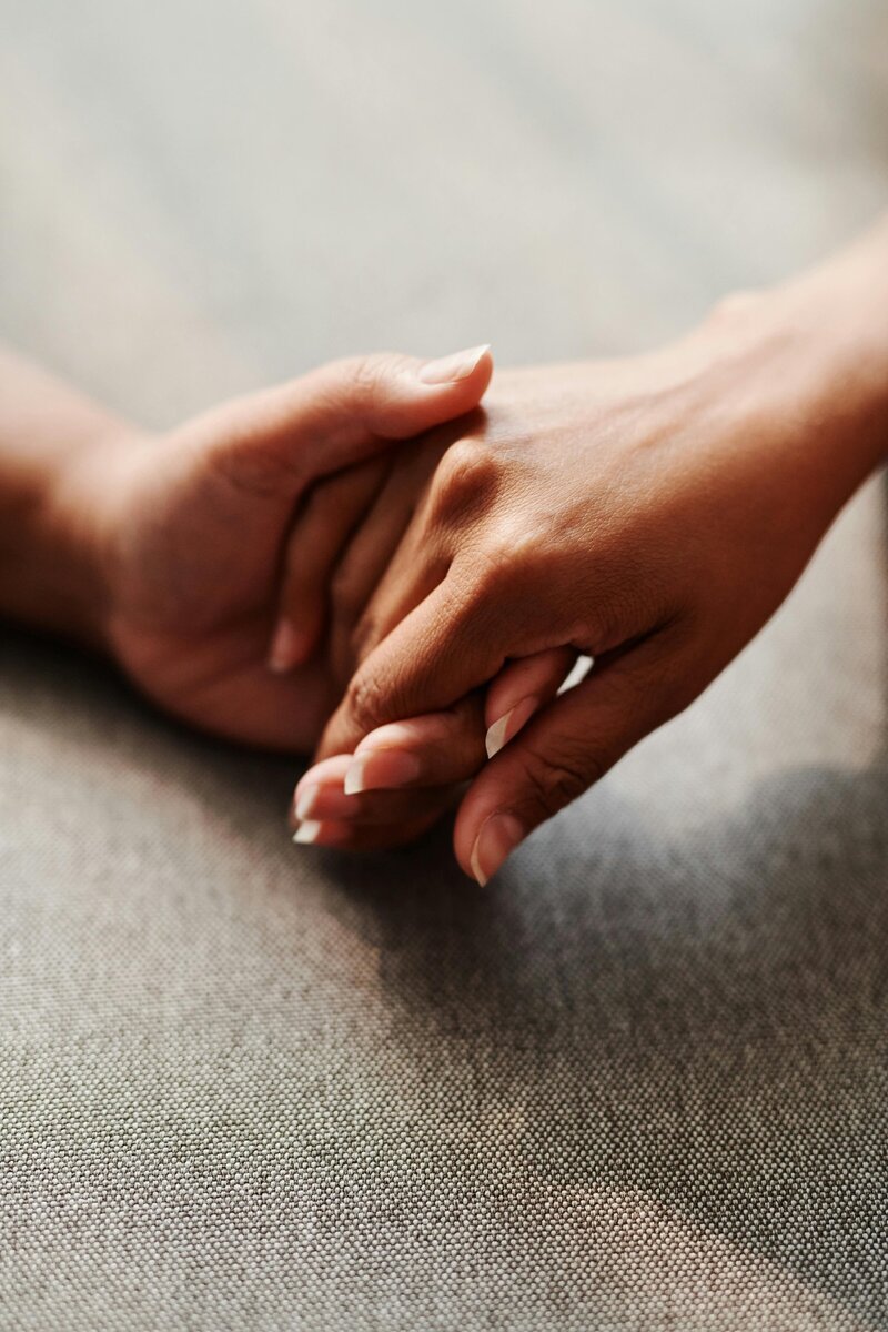 two people holding hands in an act of gentle comfort and love