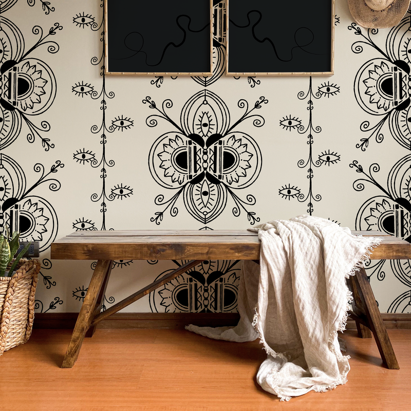 Whimsigoth style wallpaper in raven black and creamy clay display curving lines and the all seeing eye on the walls of an entryway with rustic decor