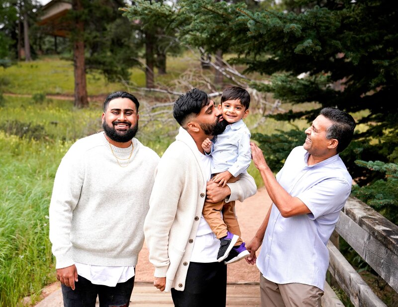 three men smiling with young boy