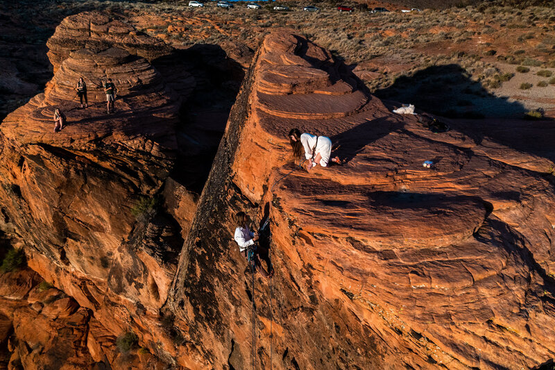 Rock climbing elopement in Utah near Kanab, couple hanging off of cliff