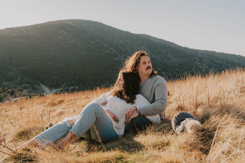 Couple laying in a field at the top of a mountain