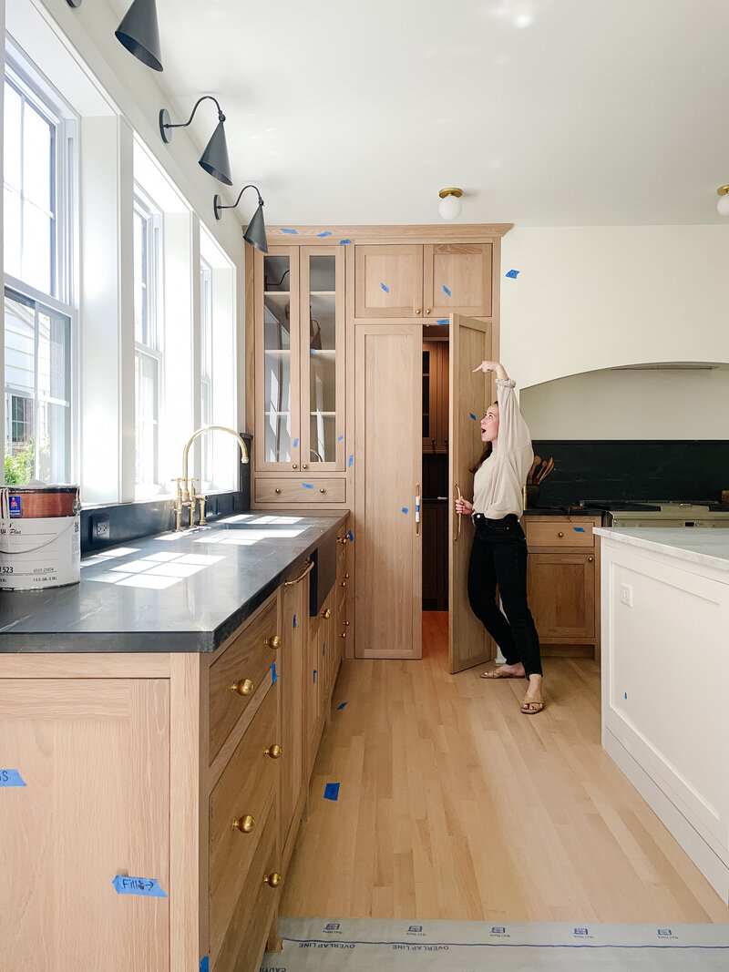 woman holds kitchen cabinet door