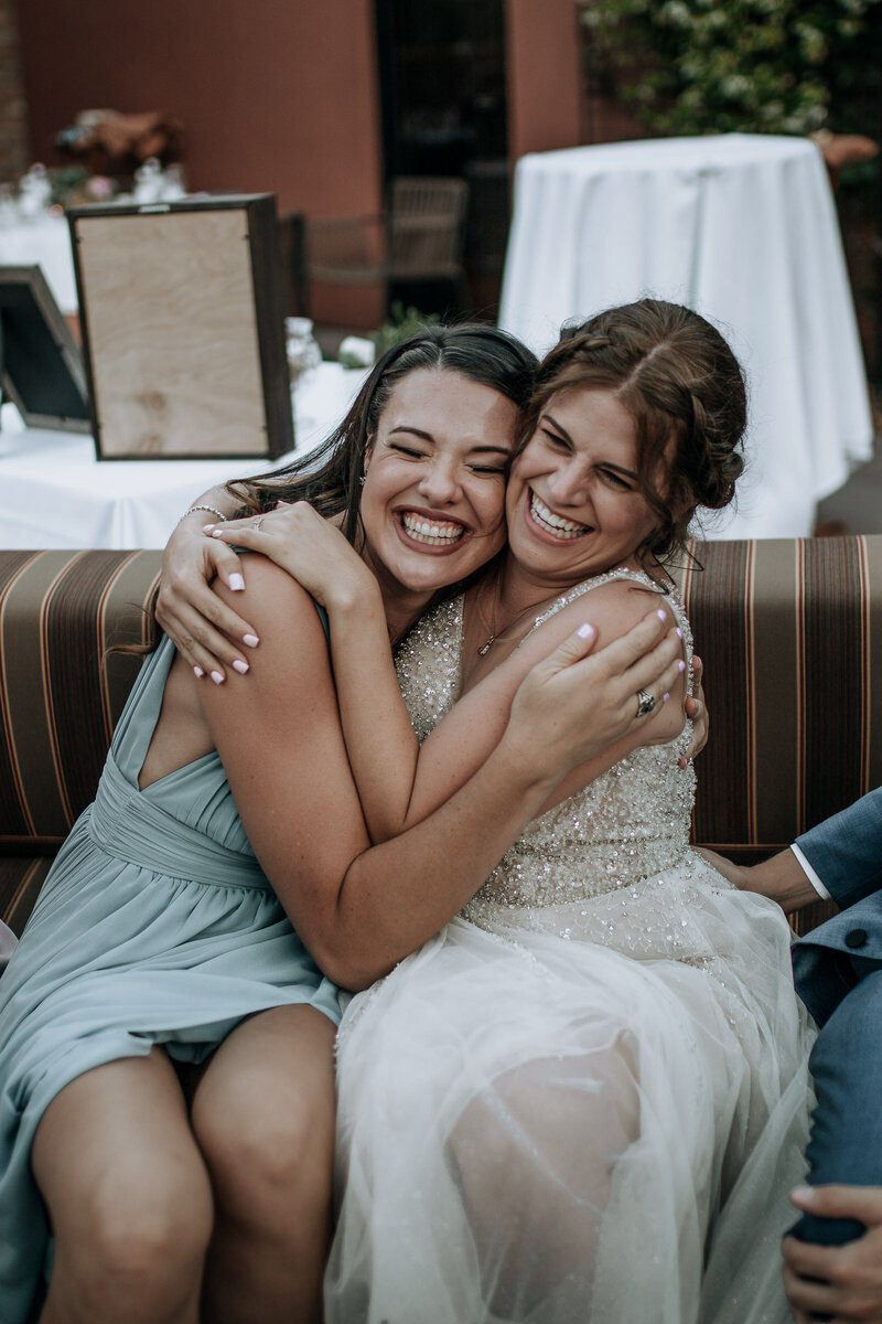 bride hugging her best friend and officiant