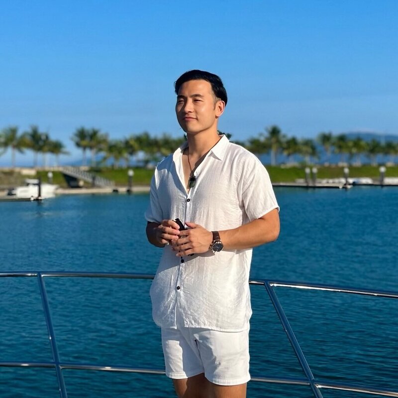 Yasushi Katsuta, founder of Japan Blend, smiling by the waterfront in a casual white outfit