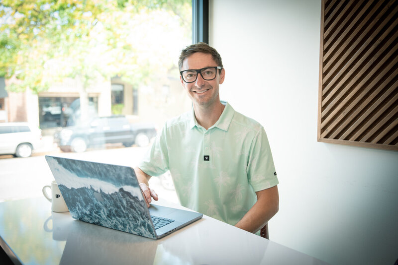 Connor walberg sitting with laptop and working on SEO for a photographers site