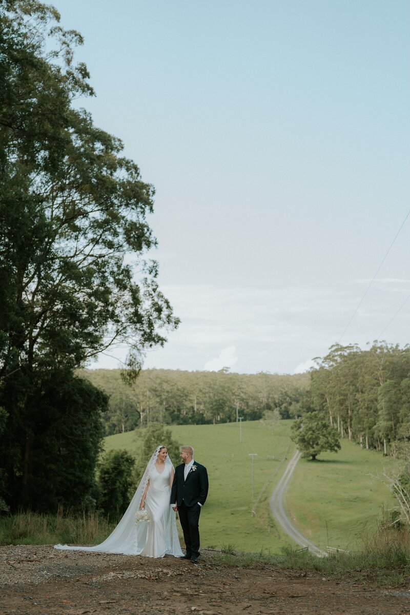 A natural and unposed wedding photo featuring the natural surroundings of the bush and farmland near Coffs Harbour