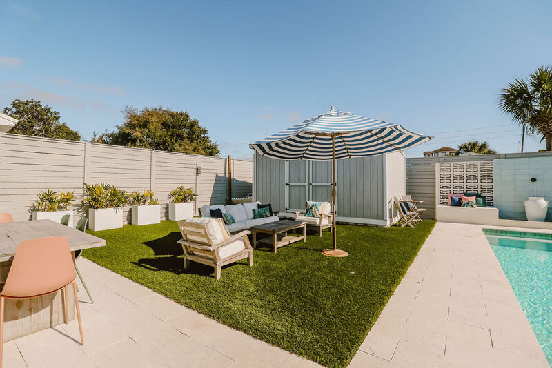 backyard with sitting area striped umbrella by pool