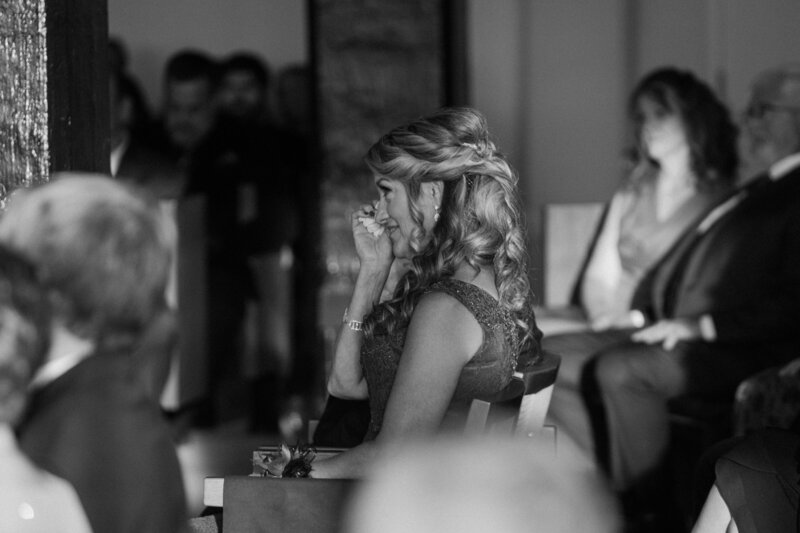 A wedding guests sitting down and wiping tears 