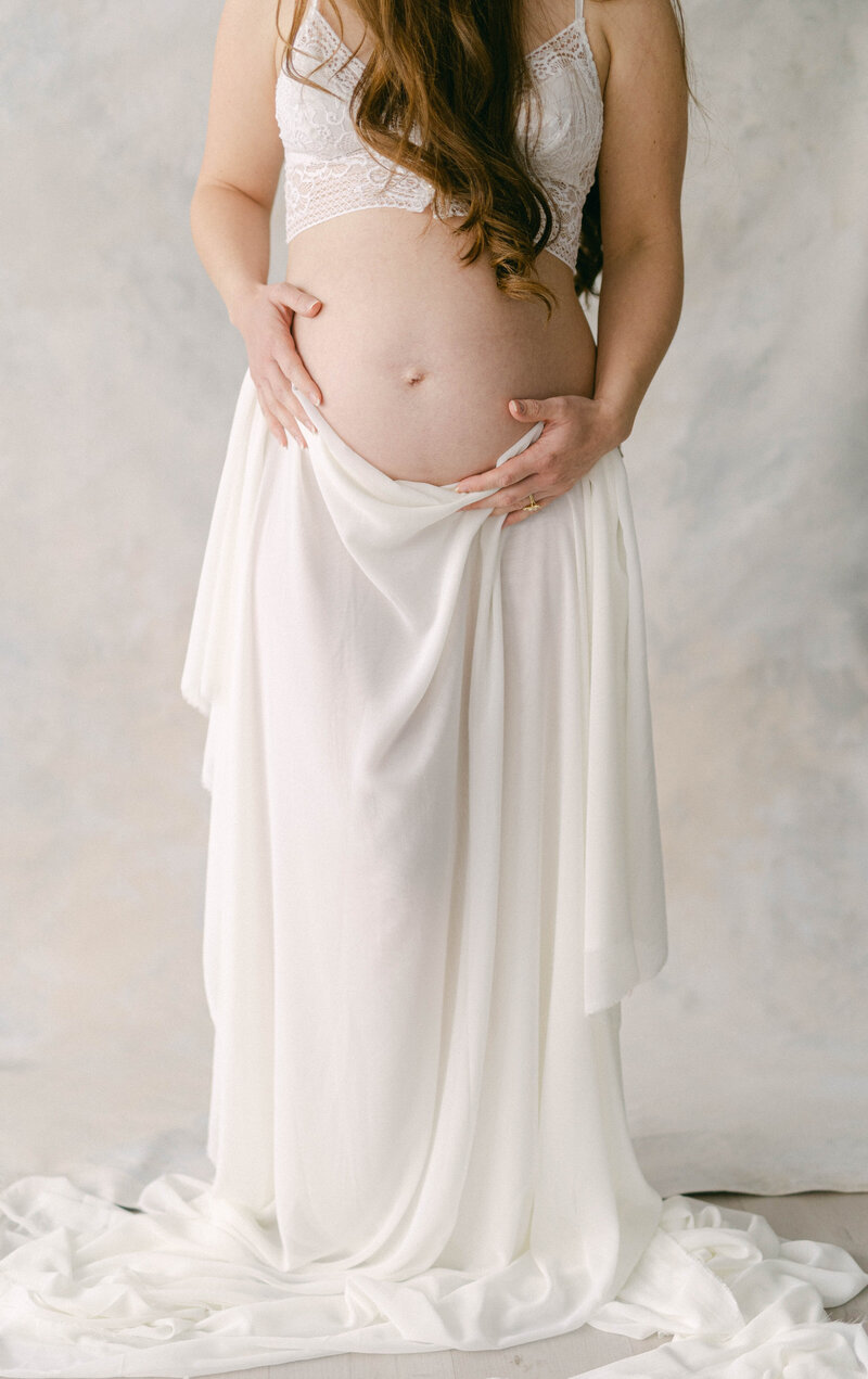 knoxville maternity photographer mom holding clothes over baby bump