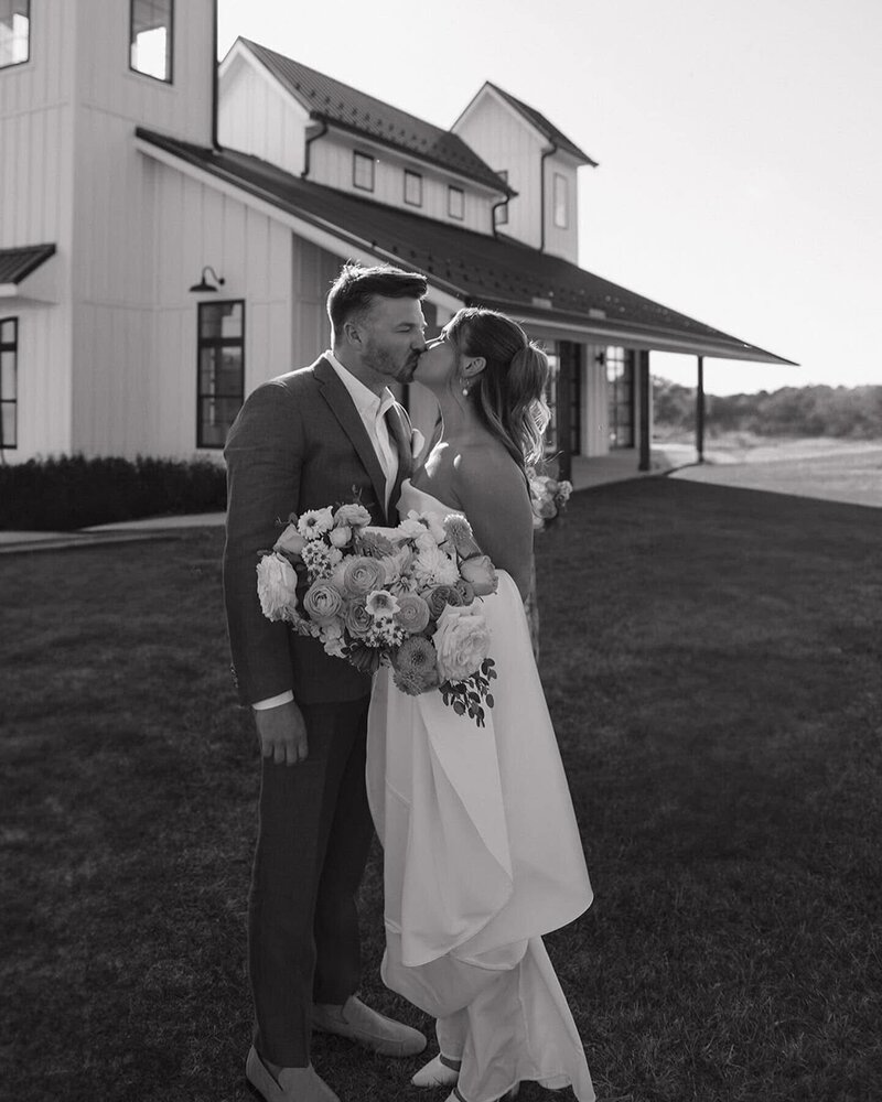 Bride and groom kissing at the backyard of the venue
