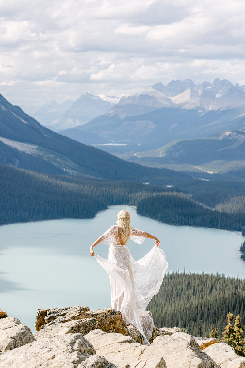 This captivating portrait captures the bride playfully twirling her dress at Peyto Lake, with the stunning Icefields Parkway in the background. The pristine lake and majestic mountain views add a sense of adventure and beauty to this joyful moment.