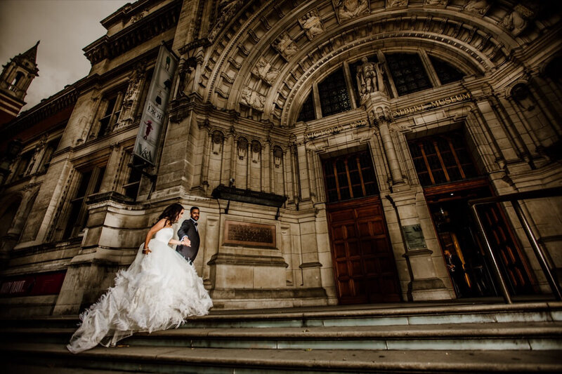 A beautiful bride and groom climbing the stairs out side of the Victoria and Albert Museum