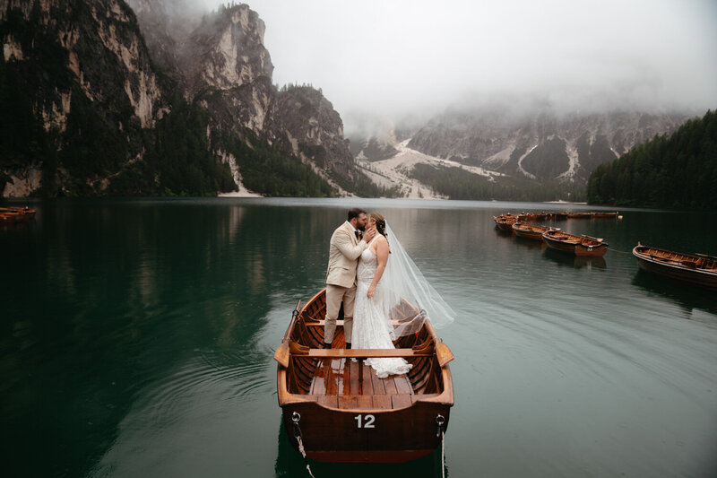 Wedding couple kissing on a rowboat on Lago di Braies for their Dolomites elopement