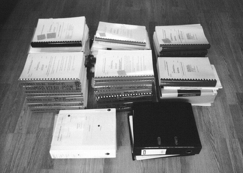 Stacks of legal documents and court binders representing the overwhelming paperwork and stress mothers face during divorce and custody battles