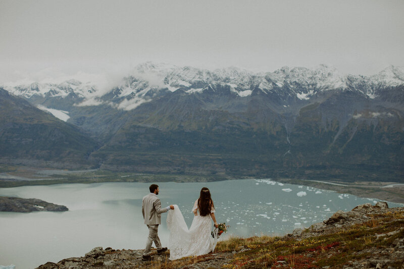 Couple walks overlooking glacial lagoon in Alaska