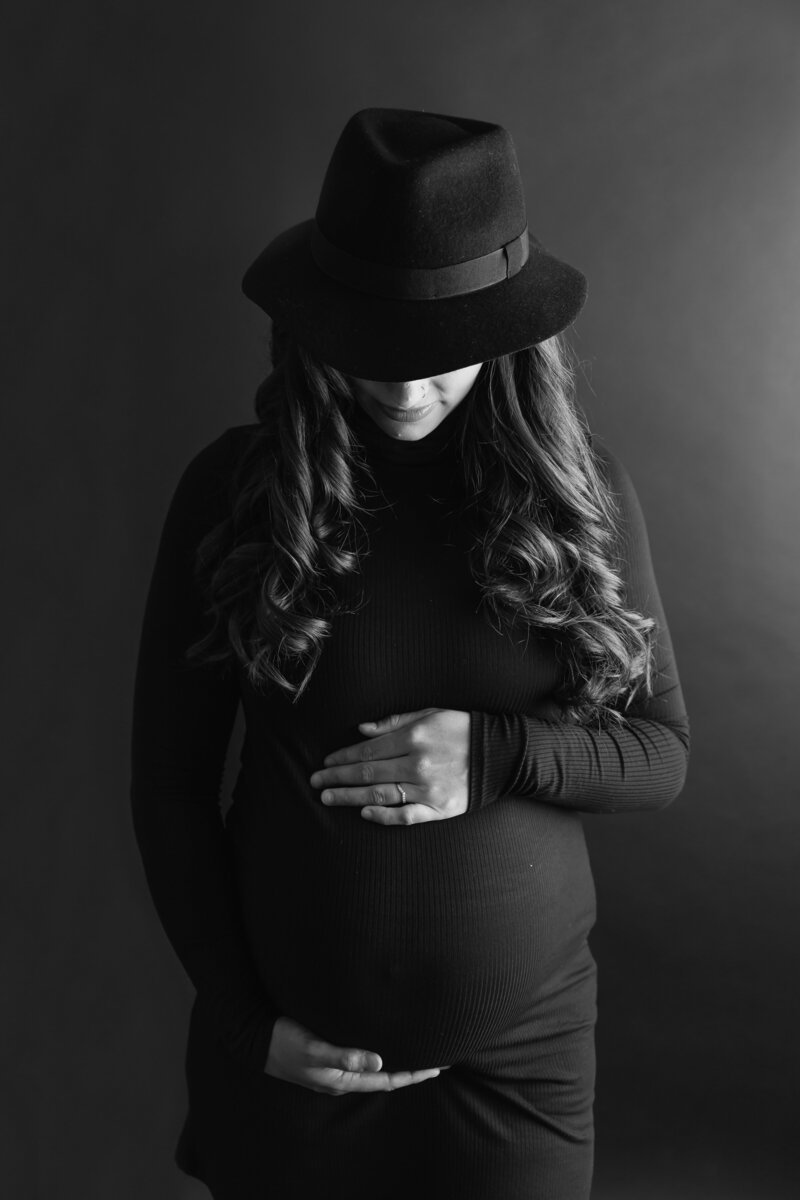 Black and white maternity, pregnant woman holding belly