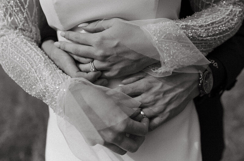Closeup of bride and groom's hands intertwined