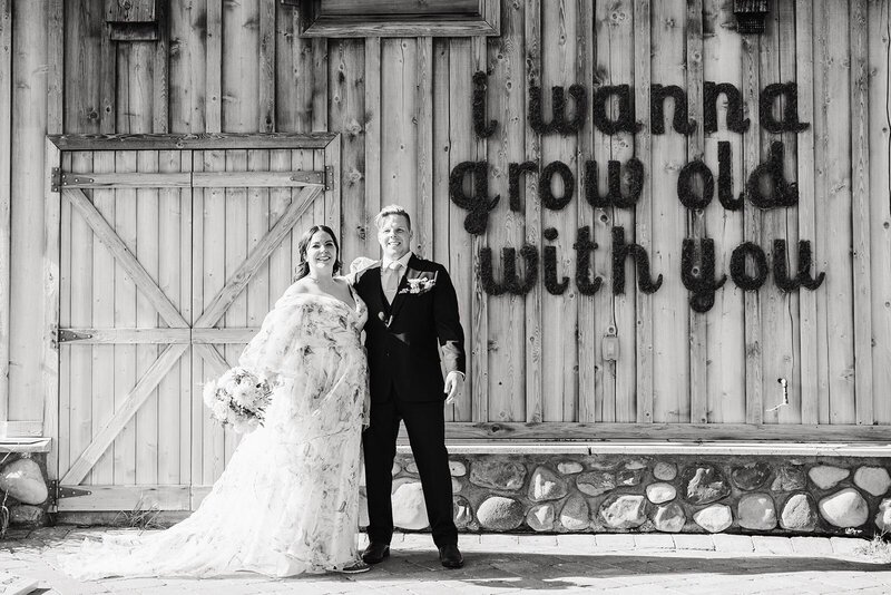 Couple with i wanna grow old with you sign on wood building