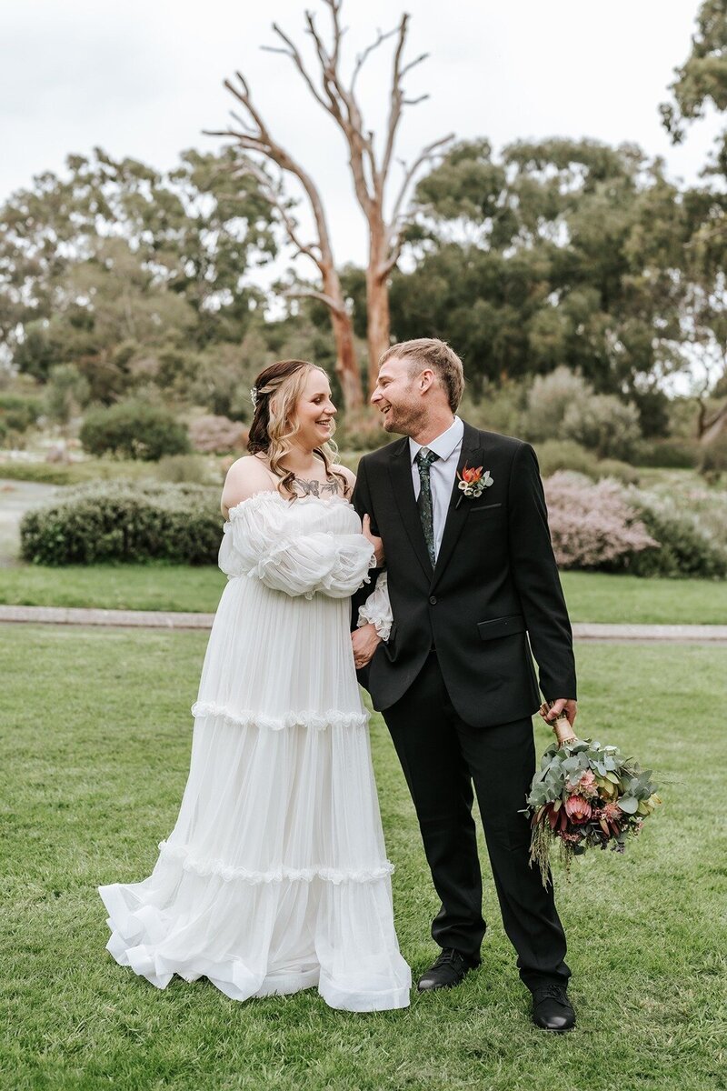 A bride and a groom posing for wedding photos in the Wittunga botanic gardens