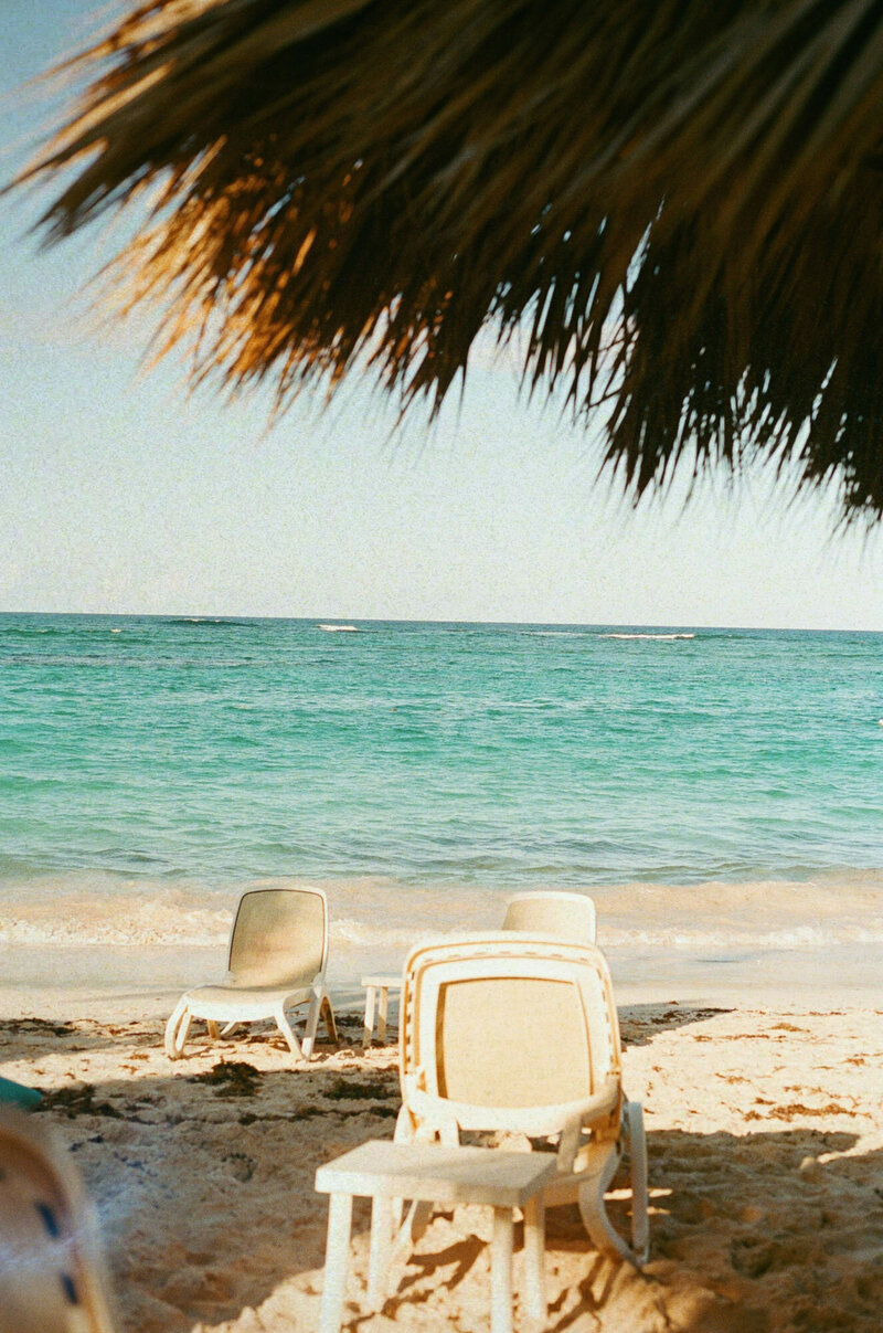 Stack of chairs on a beach with the ocean in the background