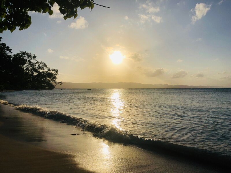 Gentle waves under a golden sunset along the Dominican coastline