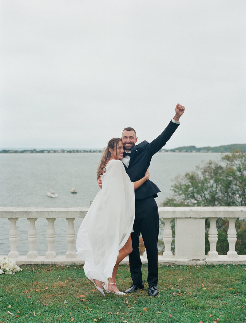 Close up of a bride with a low cowl back dress holding a dried bouquet with dainty tattoos on her arms