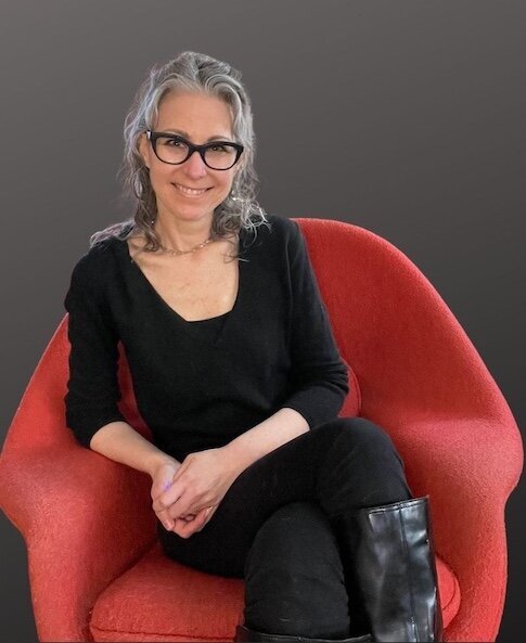 architect marketer barbara gates smiles in red womb chair