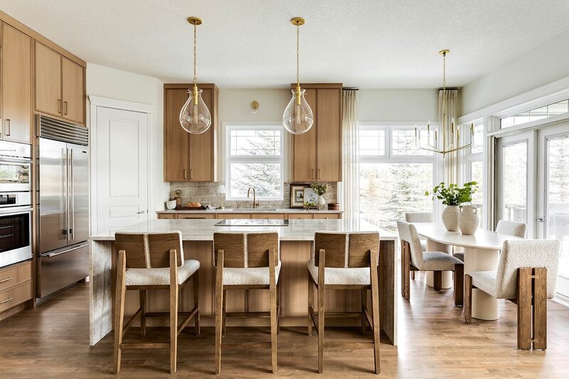 Kitchen renovation with quartzite, wooden counter stools and glass pendants. 