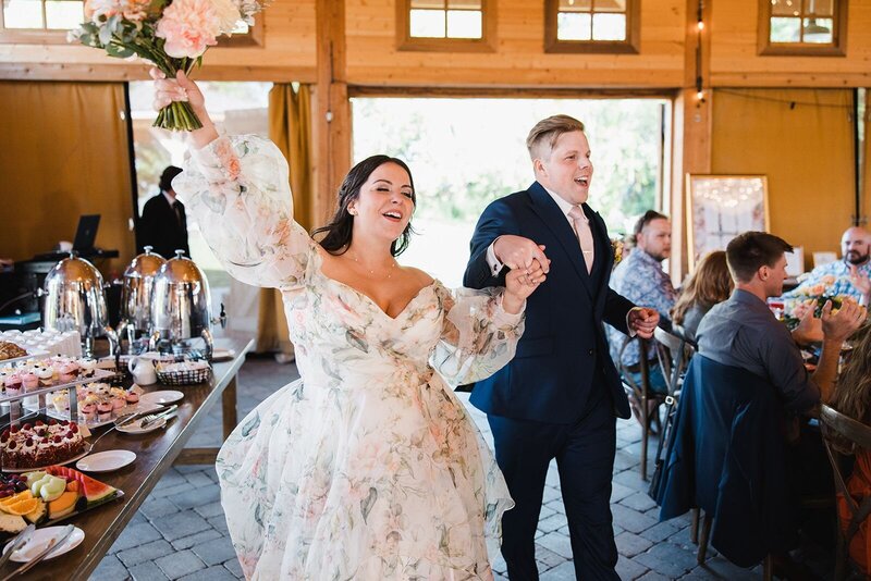 Couple entering their wedding reception celebrating