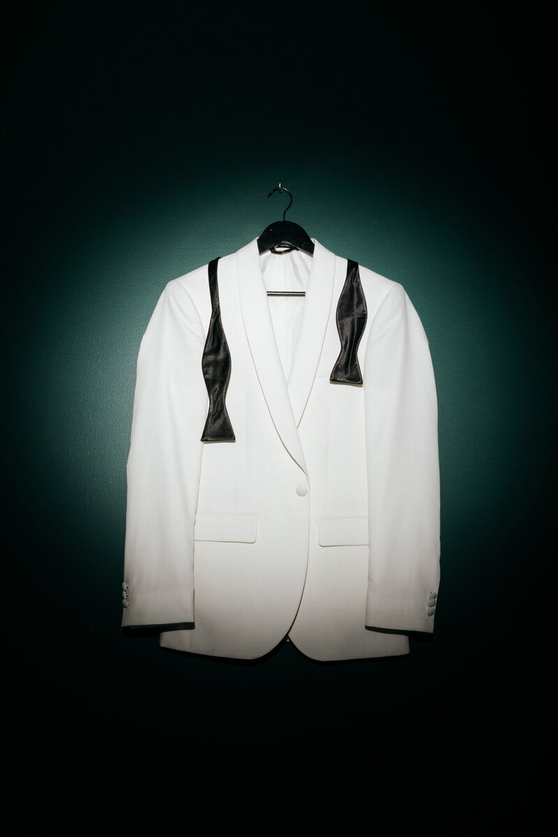 White dinner coat hanging up with black bow tie Q Jancola