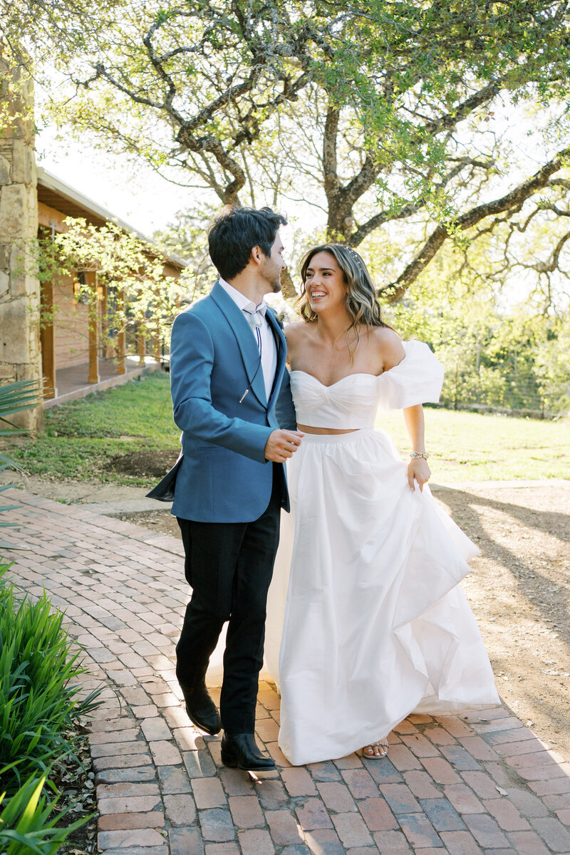 Bride and groom running outside holding hands