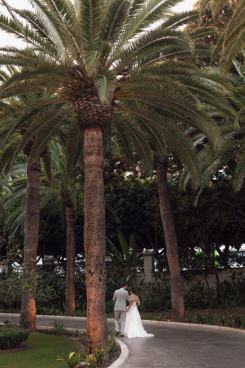 Wedding photographer captures couple taking a stroll hand in hand at their french chateau wedding.