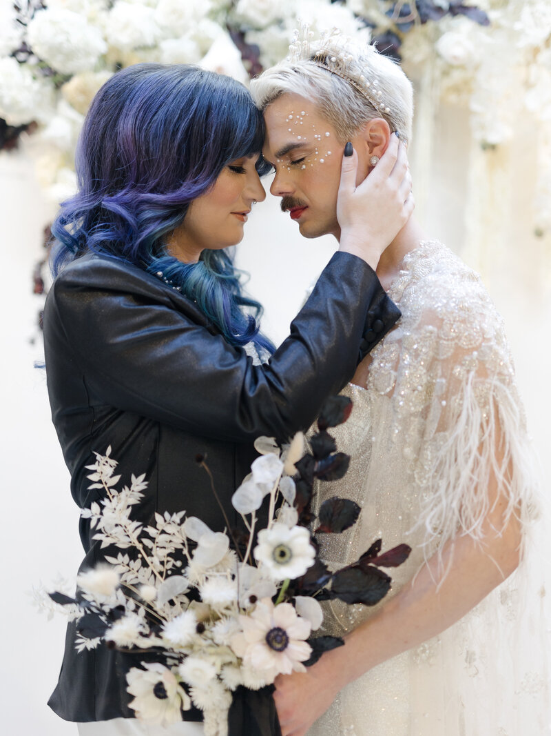 nonbinary wedding couple embracing one another with foreheads touching