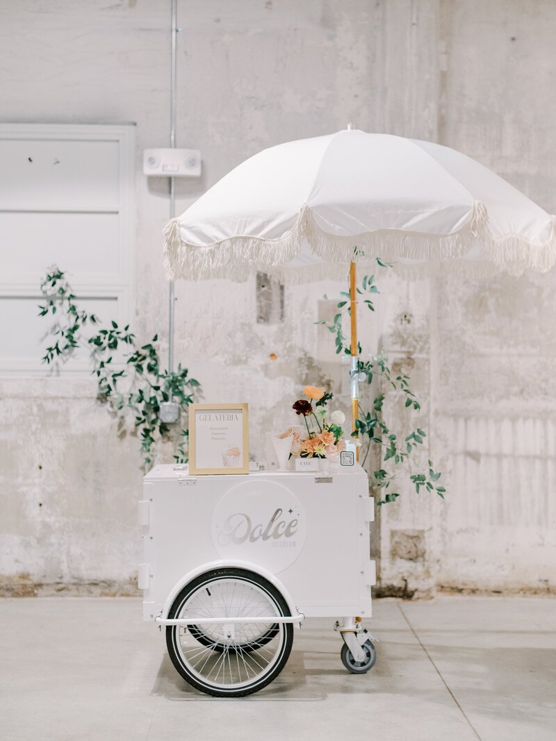Beautiful gelato cart with white umbrella and greenery