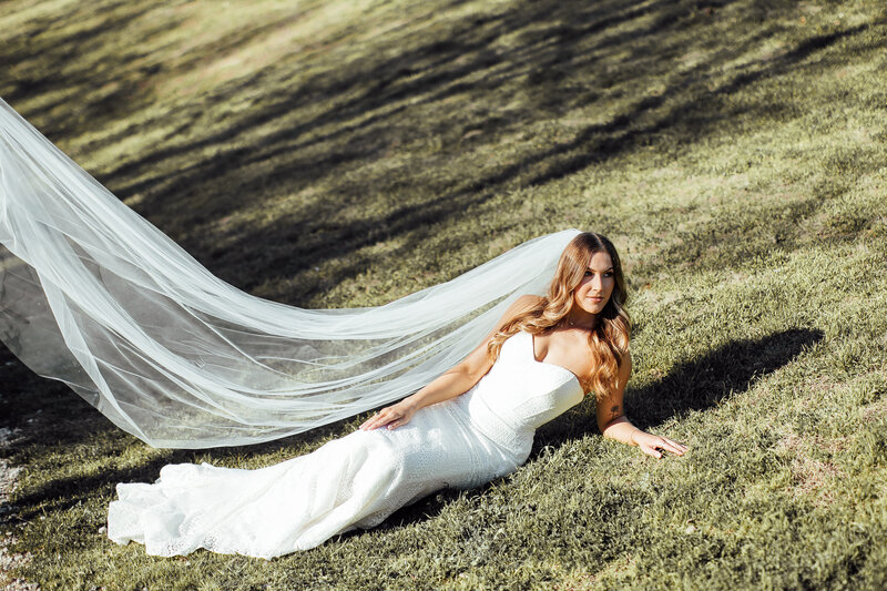 Gorgeous bride lays on grass
