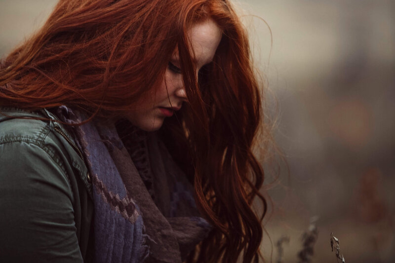 girl with red hair looking down