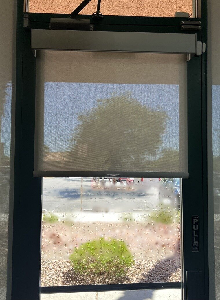 Solar roller shade mounted on a commercial glass entry door in Las Vegas