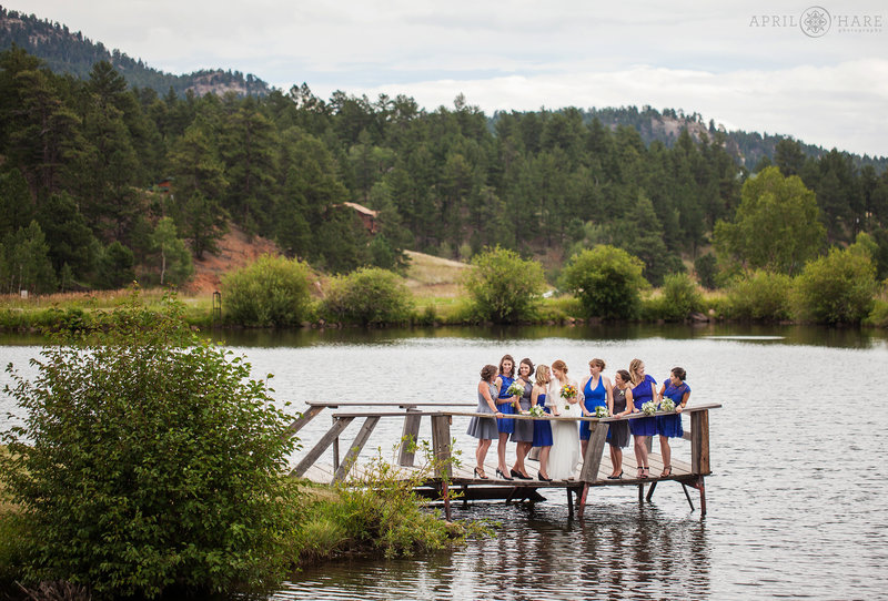 Bride with her bridesmaids on the pier  on lake at Mountain View Ranch