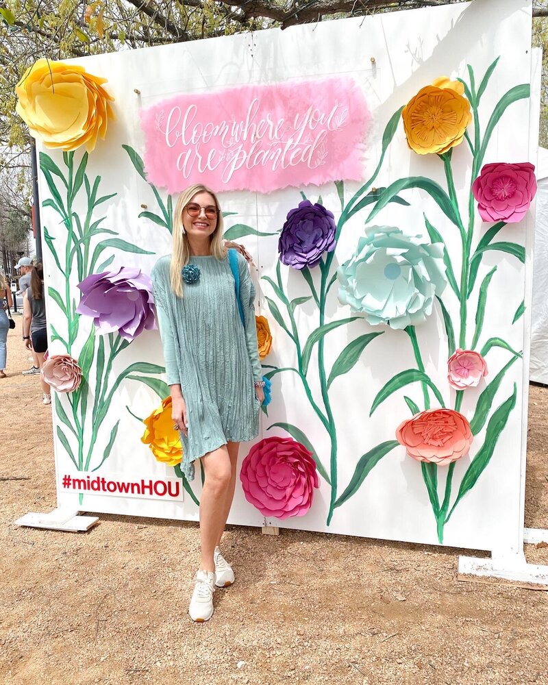 Woman posing in front of a Midtown Houston floral backdrop design