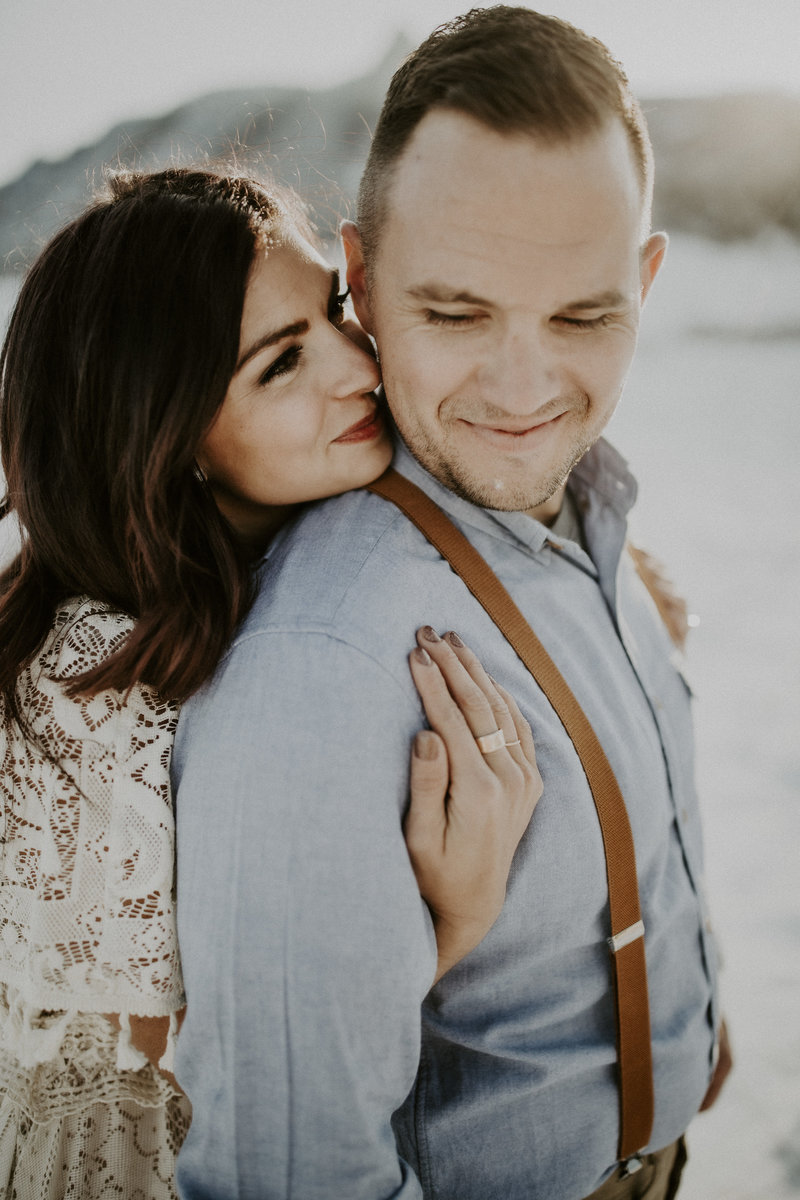 Woman hugs husband at anniversary snow photoshoot